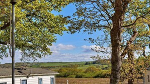A white mobile home with a fenced yard, surrounded by trees and a view of rolling hills. - Wonderful  villa for 6 people with WIFI, pool, TV and terrace (Newtown)