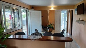A kitchen with a central island, chairs around it, and a dining table with chairs. - Apartment T3 with swimming pool and garden for your vacations in Guadeloupe (Baie-Mahault)