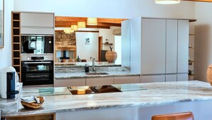 A modern kitchen with a marble countertop, built-in appliances, and a stone backsplash. - Beautiful  villa for 4 guests with WIFI and terrace (Edlingham)