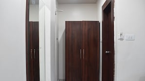 En hall med en trägarderob, en dörr och en ljusströmbrytare på väggen.