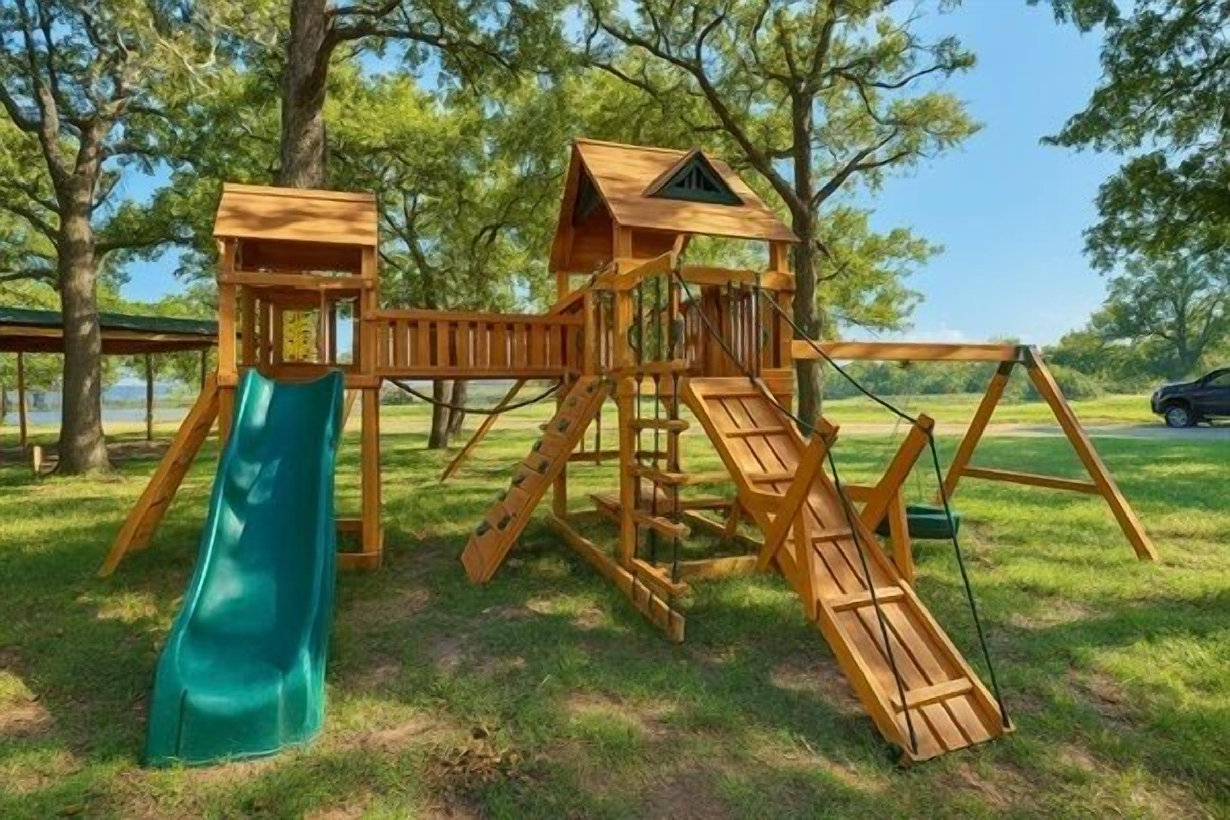 A wooden playground with a slide and climbing structures.