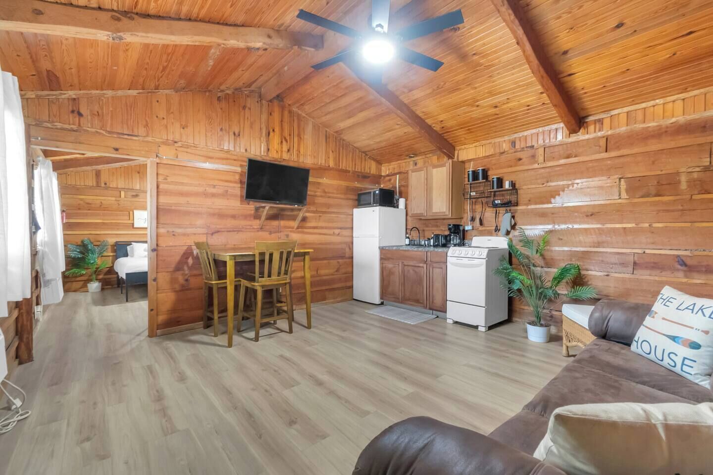 L'intérieur d'un chalet en bois comprend un coin repas, une cuisine et un canapé.
