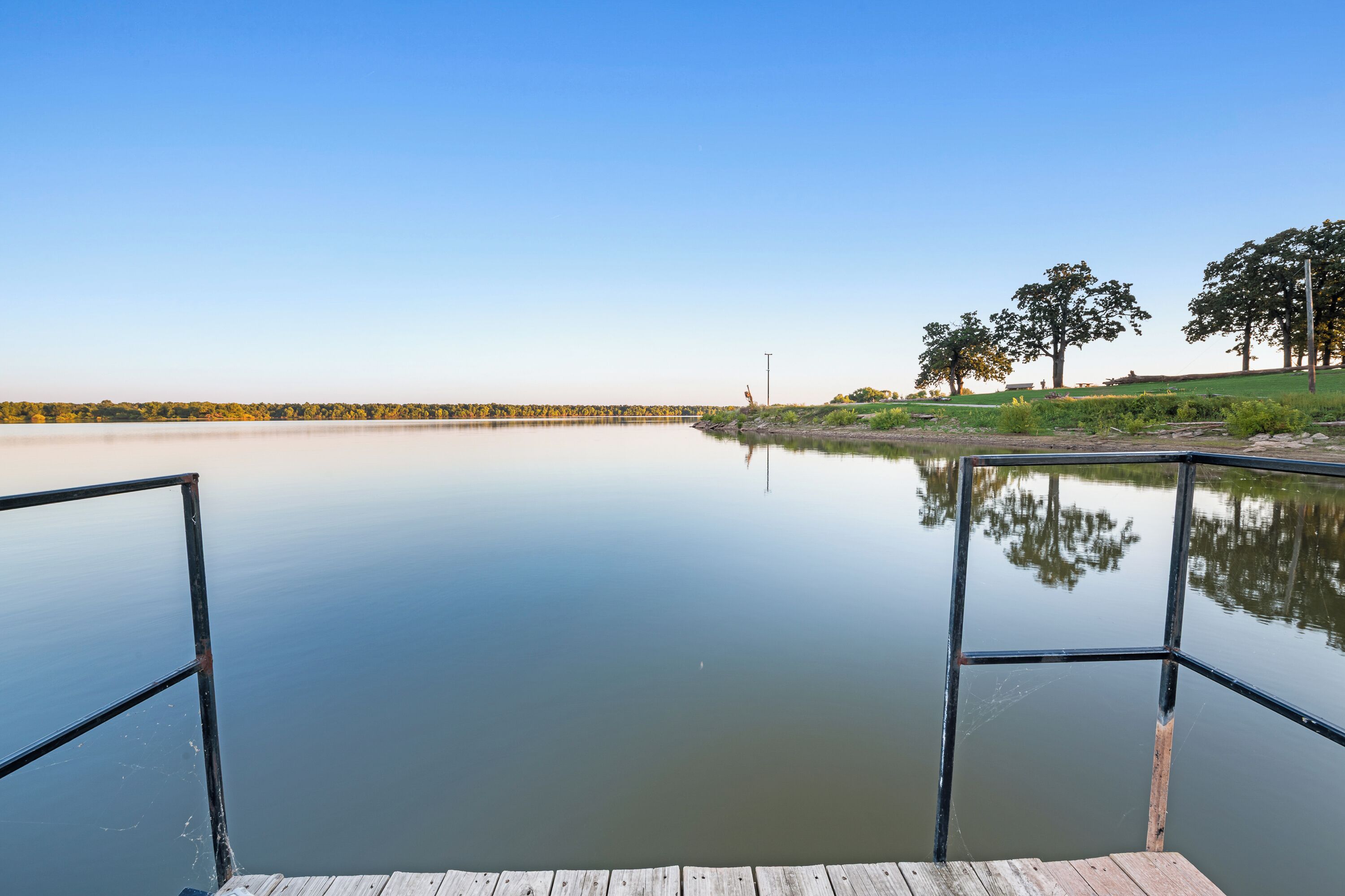 A calm lake with a wooden dock extending into the water.