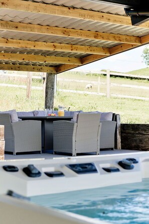 Patio esterno con mobili in vimini e zona piscina.