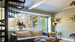 A cozy living room with a wooden coffee table, a sofa, and a bookshelf.