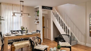 A dining area with a wooden table, chairs, and a bench. There is a staircase leading to another room. - Wonderful  villa for 6 guests with WIFI, terrace and pets allowed (Ffestiniog)