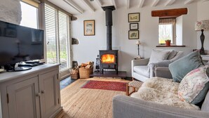 Una sala de estar acogedora con chimenea, televisor y asientos cómodos.