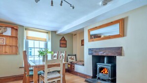 Una habitación acogedora con chimenea, muebles de madera y una ventana con persianas.
