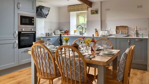 Una cocina moderna con armarios grises, una mesa de comedor de madera y sillas.