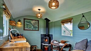 Una habitación acogedora con barra de madera, chimenea, mesa de comedor y una zona de estar confortable.