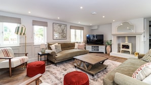 A living room with a sofa, armchairs, a coffee table, and a television. - Tuffs Farm (Kings Langley)