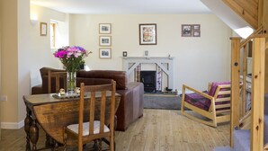 Una sala de estar acogedora con chimenea, muebles de madera y una escalera.