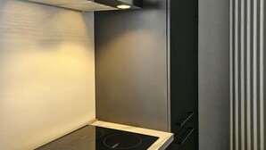 En del av ett modernt kök med en inbyggd spis och en mikrovågsugn.
