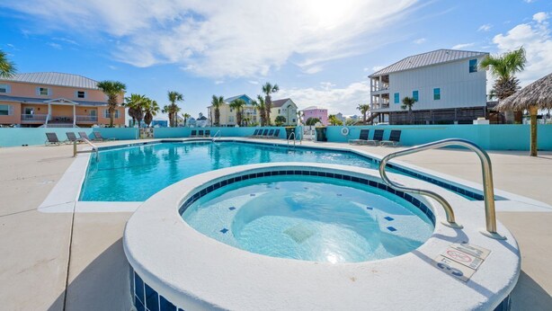 A swimming pool with lounge chairs, a hot tub, and a clear blue sky. - Spacious Family-Friendly | Pet-Friendly Beach House | Pool | Sleeps 10 (Gulf Shores)