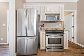 Una cocina con un refrigerador de acero inoxidable, un microondas y un horno.
