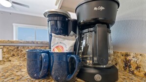 A coffee maker, two mugs, and a packet of coffee on a kitchen counter. - Spacious Family-Friendly | Pet-Friendly Beach House | Pool | Sleeps 10 (Gulf Shores)