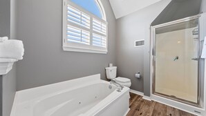A bathroom with a bathtub, toilet, and walk-in shower. - Spacious Family-Friendly | Pet-Friendly Beach House | Pool | Sleeps 10 (Gulf Shores)
