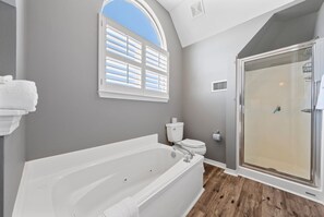 A bathroom with a bathtub, toilet, and walk-in shower. - Spacious Family-Friendly | Pet-Friendly Beach House | Pool | Sleeps 10 (Gulf Shores)
