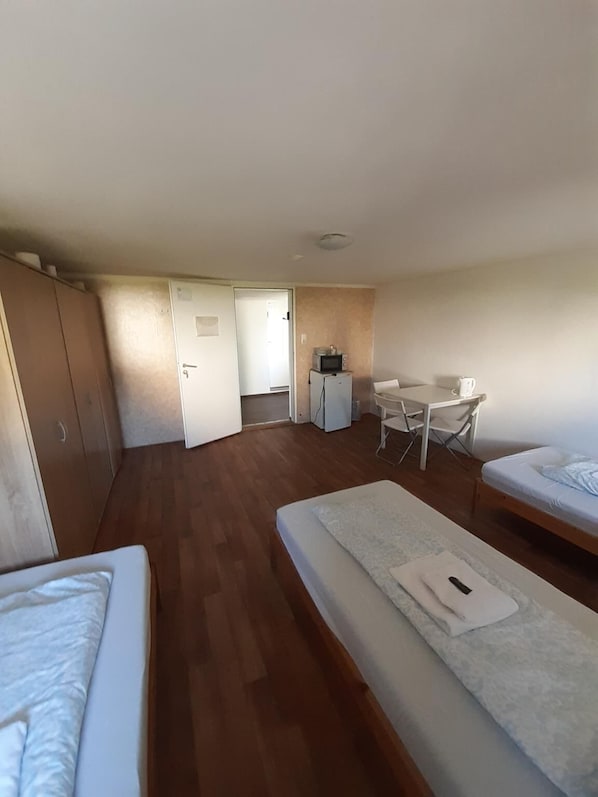 A compact room with a bed, a desk, and a kitchenette. - 2-Rent Group Hostel Rooms&Apartments EVE168 (Munich)