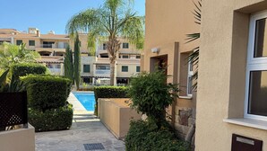A courtyard with a pool, stone flooring, and outdoor seating.