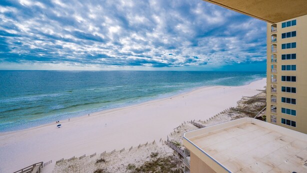 A beach view from a balcony with a clear sky and ocean. - Phoenix I 1141 3 Bedroom Condo (Orange Beach)