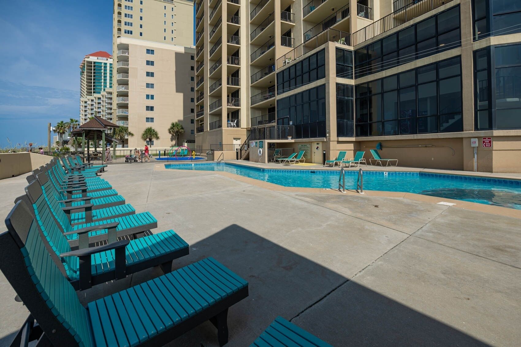 A pool area with blue lounge chairs and a small pool.