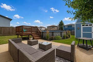 A backyard with a wooden deck, outdoor furniture, and a swimming pool. - Modern Retreat With Private Pool & Yard 3 Bedroom Home (Tinley Park)