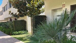 A pathway leading to a building with a well-maintained hedge and a palm tree. - Holiday Home 'Great Townhouse Close To The Beach' with Sea View, Wi-Fi and Air Conditioning (Manilva)