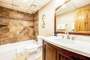 Une salle de bain moderne équipée d’une baignoire, de toilettes et d’un lavabo.