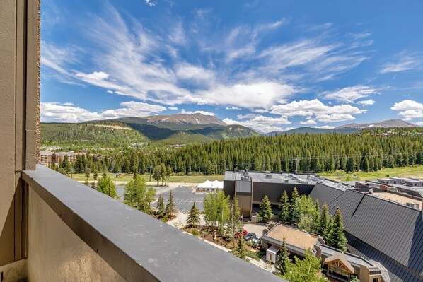 Vue sur une montagne depuis le balcon d’un hôtel, avec un parking et des bâtiments au premier plan.