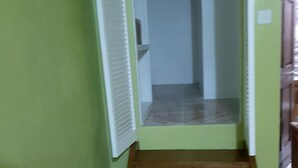 Un estrecho pasillo con una escalera de madera que conduce a una habitación.