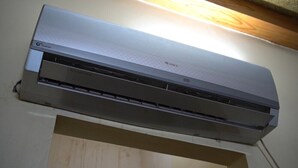 Eine wandmontierte Klimaanlage mit Markenlogo und Bedienfeld.