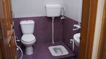 A small bathroom with a toilet, bidet, and sink.