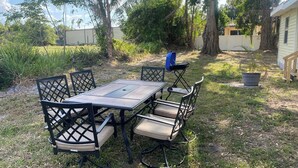 An outdoor dining area with a table and chairs, surrounded by grass and trees. - Palmetto Ellenton | Nature + Smart Comfort (Palmetto)