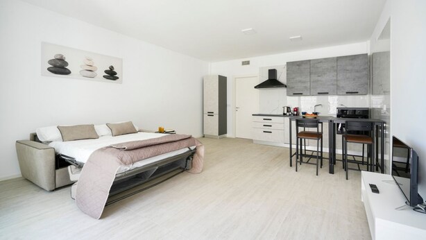 A modern, compact living space with a convertible sofa bed, a kitchenette, and a dining area. - GuestHost - Charming 67 sqm apartment, perfect for 4 people, located on the ground floor of a recently built building.The property is located in a residence with a concierge active all day; outside the house there are gym equipment that can be used freel (Bari)