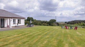 A house with a lawn and outdoor seating area. - ARD NA MARA, pet friendly, with open fire in Culdaff, County Donegal (Culdaff)