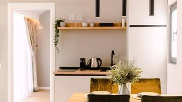 Une cuisine moderne avec un plan de travail en bois, une machine à café et un vase rempli de fleurs.