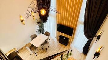 Un interno moderno con una scala, una zona pranzo e un angolo salotto.