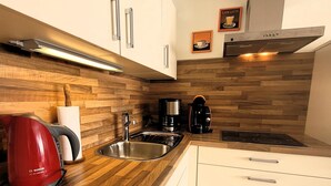 A modern kitchen with wooden cabinetry, stainless steel appliances, and a Bosch kettle. - Apartment in Winterberg Near Ski Lift (Winterberg)