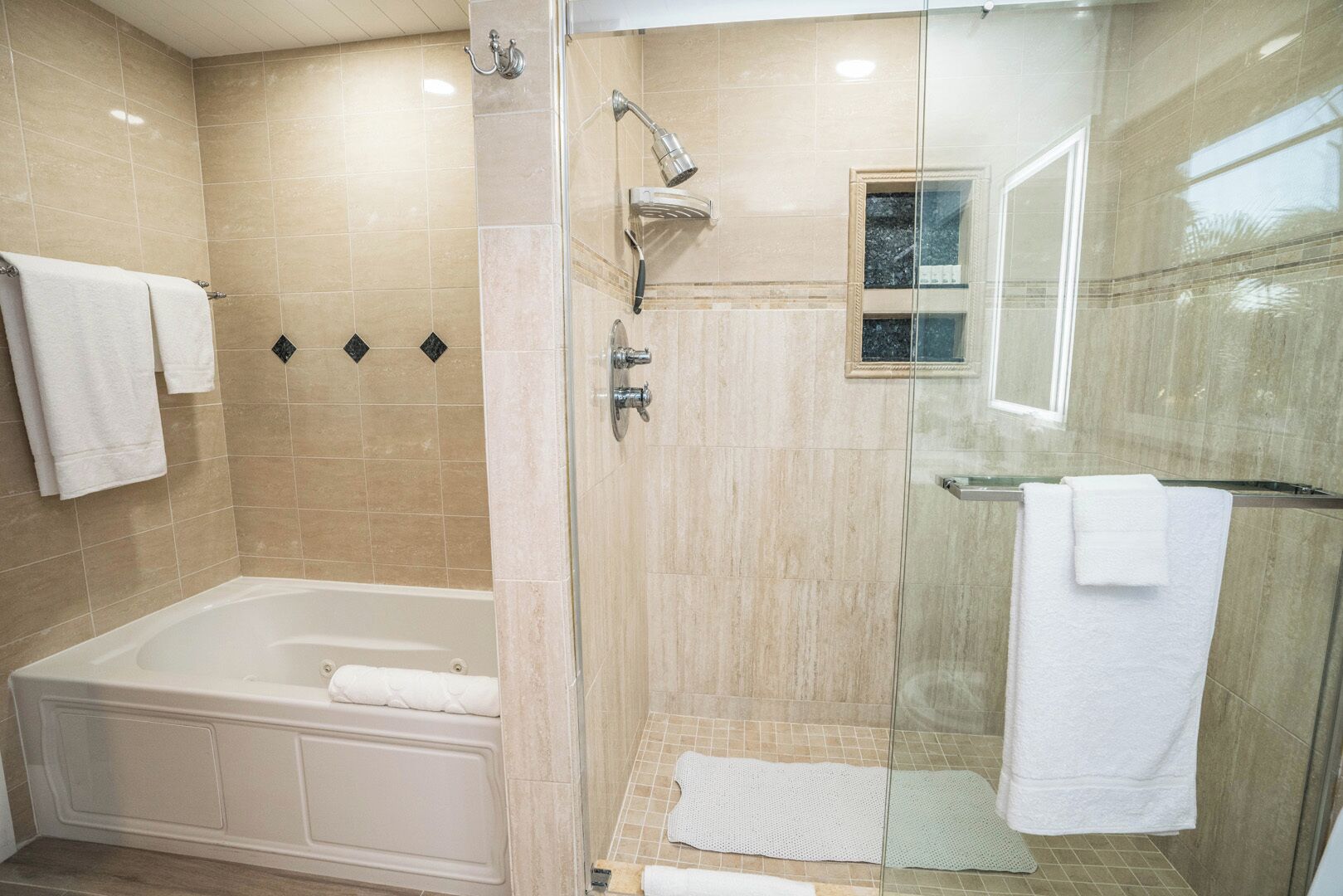 Un bany modern amb dutxa tancada per vidre, una banyera separada i un lavabo ampitronat per vidre.