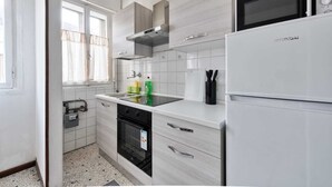 A modern kitchen with white cabinetry, a built-in microwave, and a stainless steel range hood. - Cozy Miranese Venice (Chirignago-Zelarino)