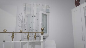 Ein Badezimmer mit einer weißen Badewanne, einem Fenster mit Vorhang und einem weißen Schrank.