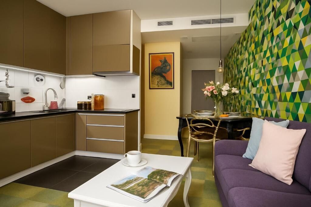 A compact living space with a kitchenette, a dining area, and a seating area with a sofa and a table.