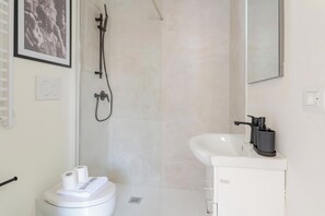 A modern bathroom with a toilet, sink, and shower. - Torino essential Loft (Torino)