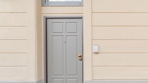 A closed door with a rectangular panel design, a round doorknob, and a small mailbox on the wall to the right. - Torino essential Loft (Torino)