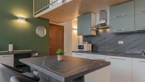 A modern kitchen with a marble countertop, grey cabinets, and a wooden ceiling. - Torino essential Loft (Torino)