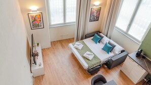 A compact hotel room with a bed, bedside table, and a desk area. - Torino essential Loft (Torino)