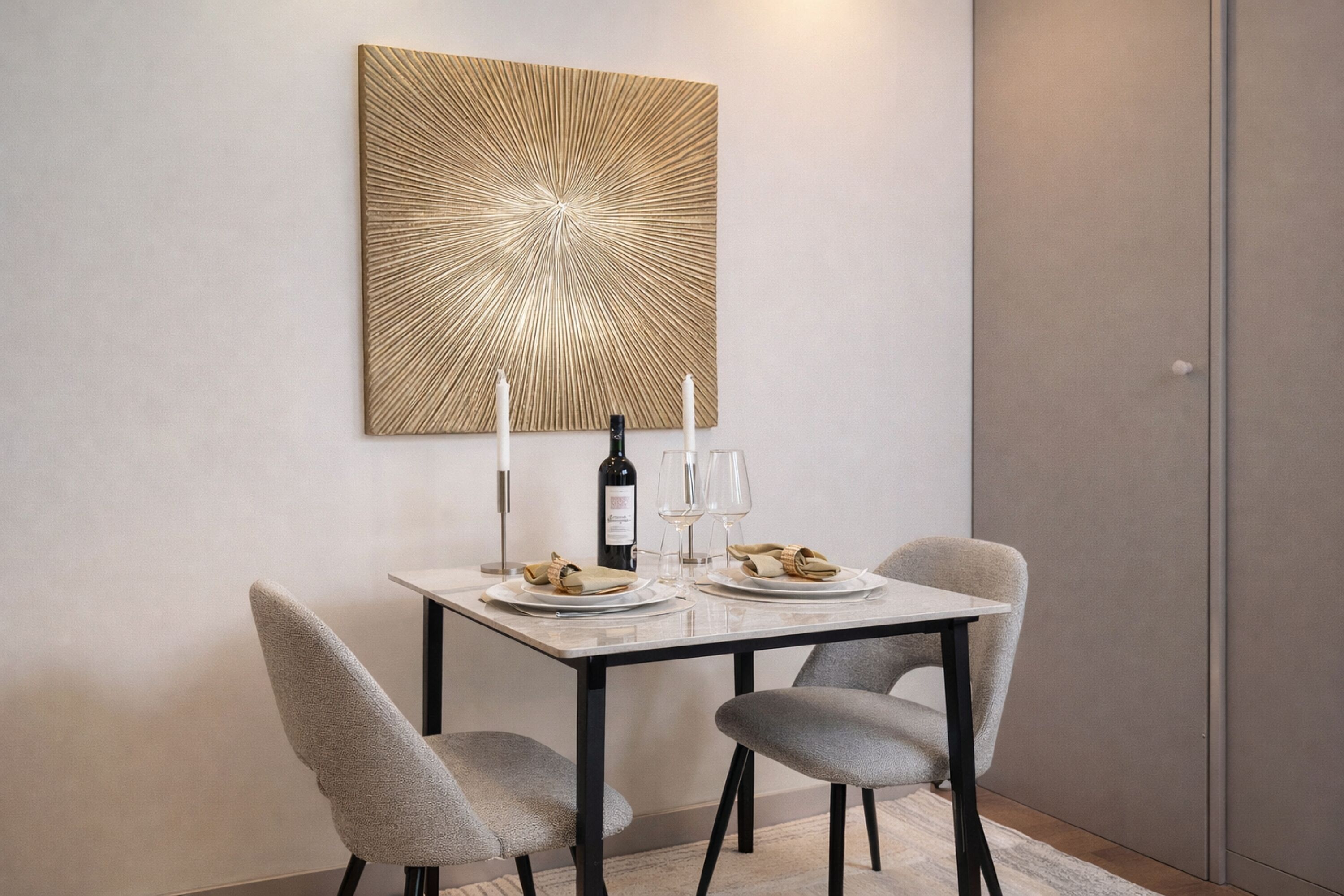 Un tavolo da pranzo con due sedie, una bottiglia di vino e dei bicchieri.
