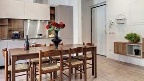 Una cocina moderna con armarios de madera, una campana extractora de acero inoxidable y una mesa de comedor con seis sillas.