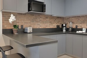 Fridge, microwave, coffee/tea maker, cookware/dishes/utensils